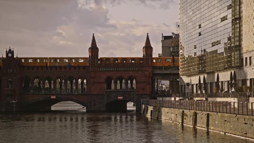 Train crosses the bridge over the river in the city