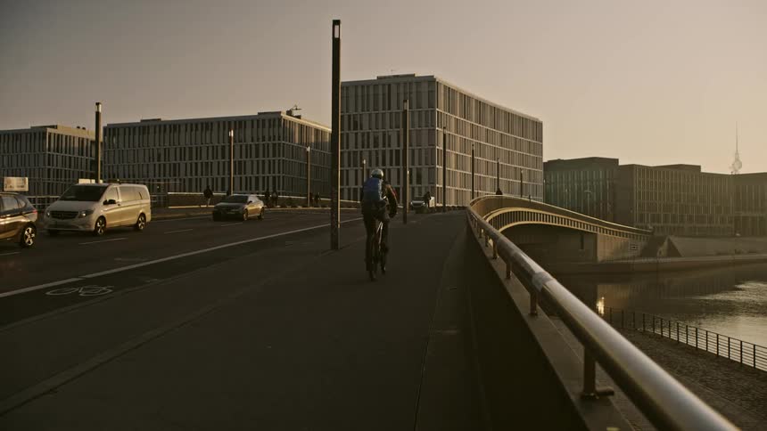 Cars and people riding bikes are displayed in a downtown city