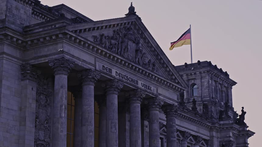 A flag blows in the wind on top of a government building