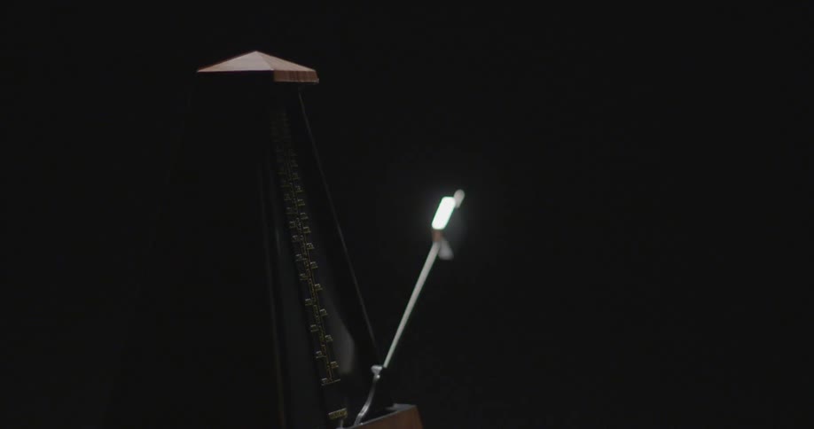 A metronome ticks back and forth