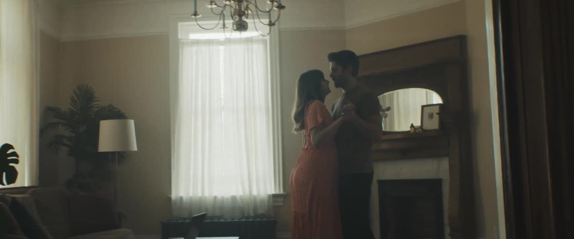 Man and pregnant woman dance in the living room