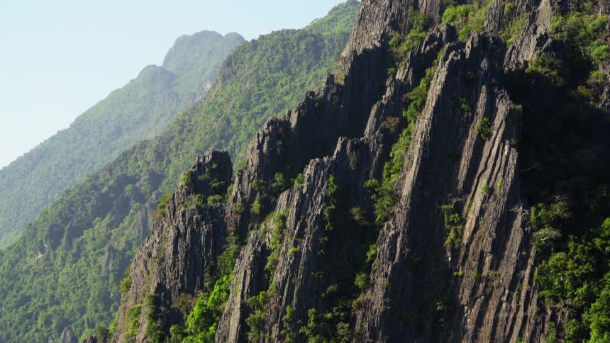 A cliff with plants and the sky in the background
