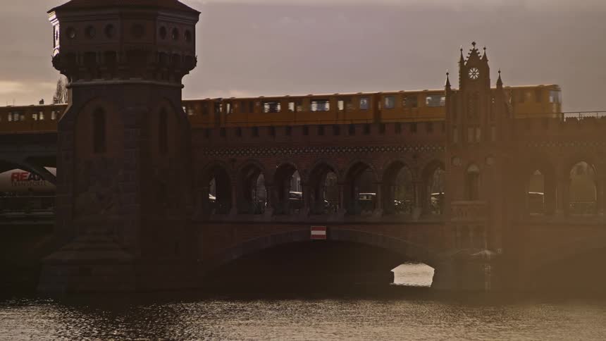 Trains move back and forth on top of a bridge over a river