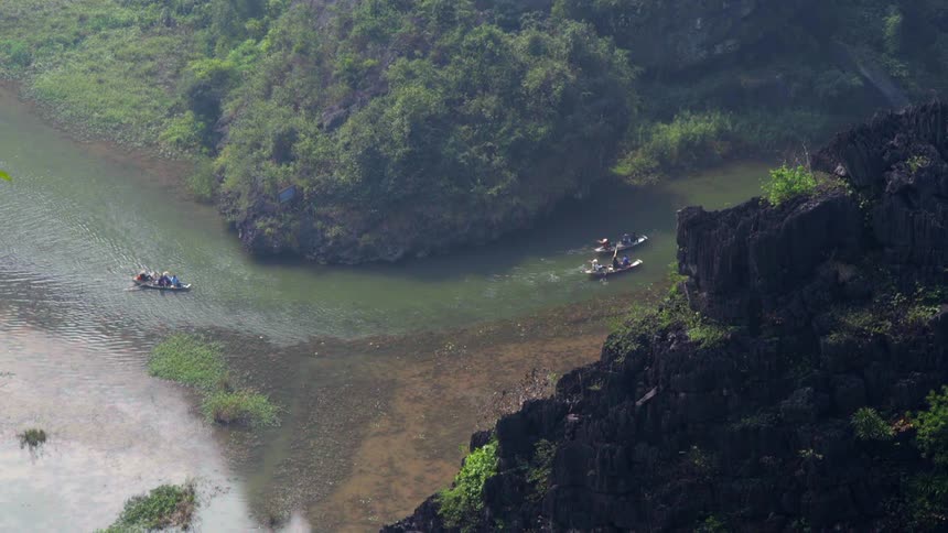 People in three canoes go around a bend in a river