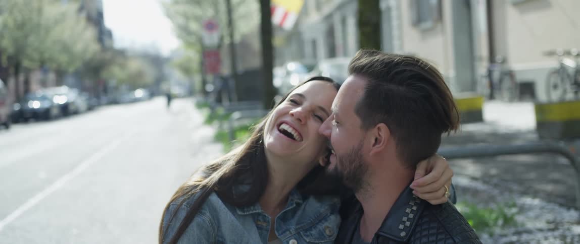 Couple cuddles each other in the street