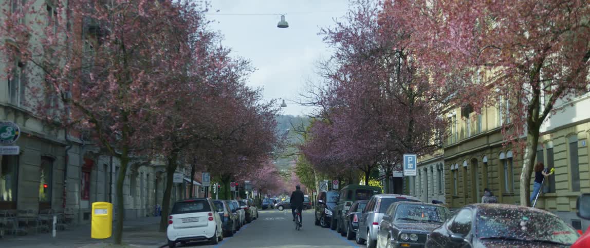A man in black walks down the narrow street
