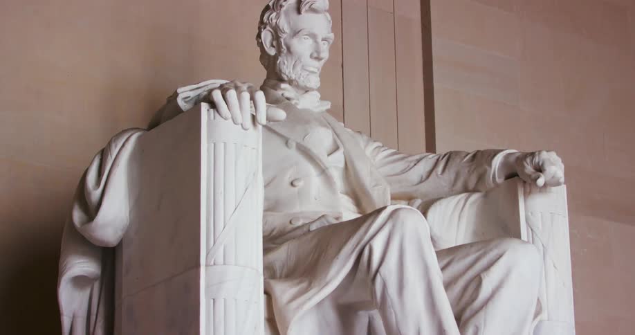 Abraham lincoln sits in a chair at the lincoln memorial