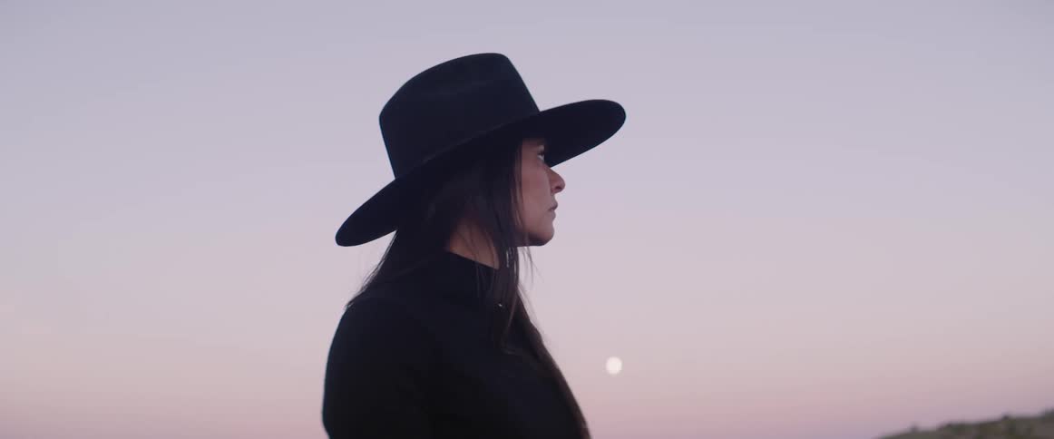 Woman sitting on the horse looks around at dusk