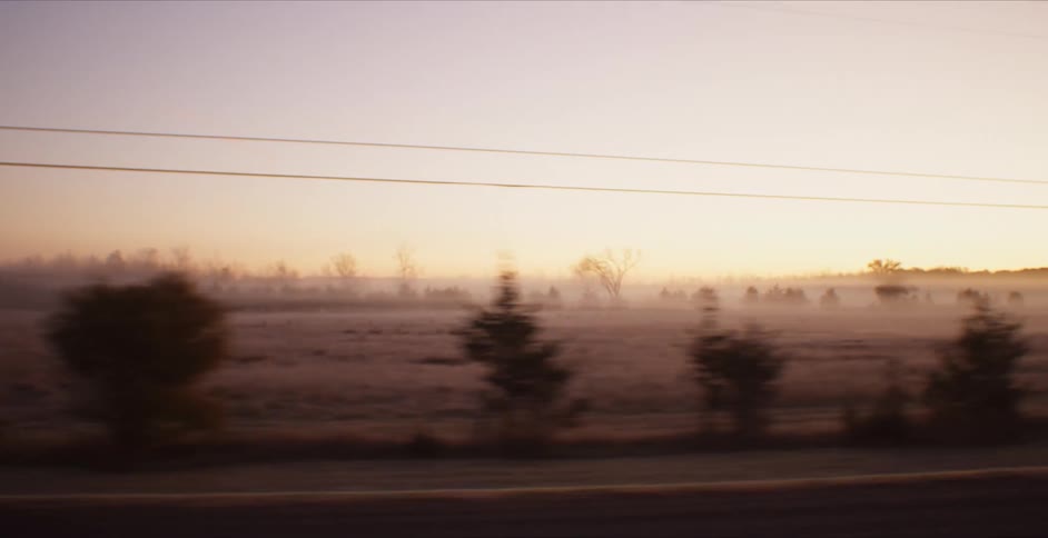 Cars are driving on a highway in a rural area