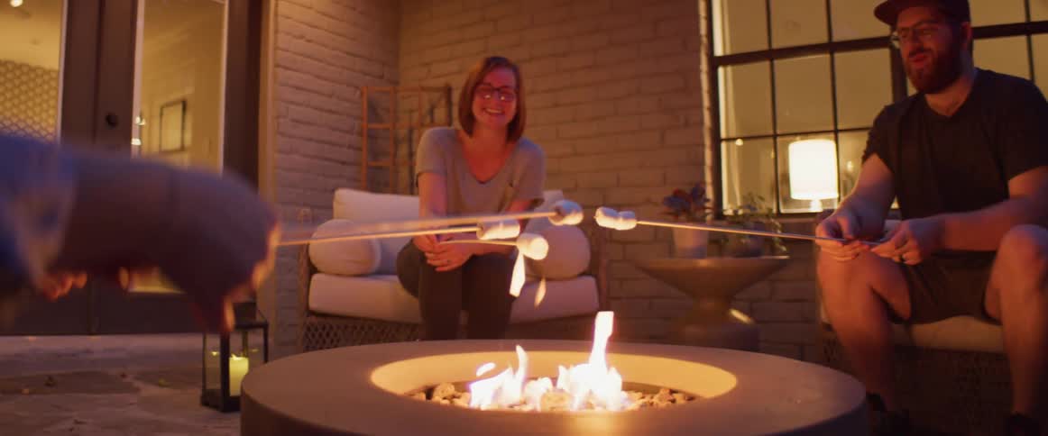 A group of people roast marshmallows outside their home