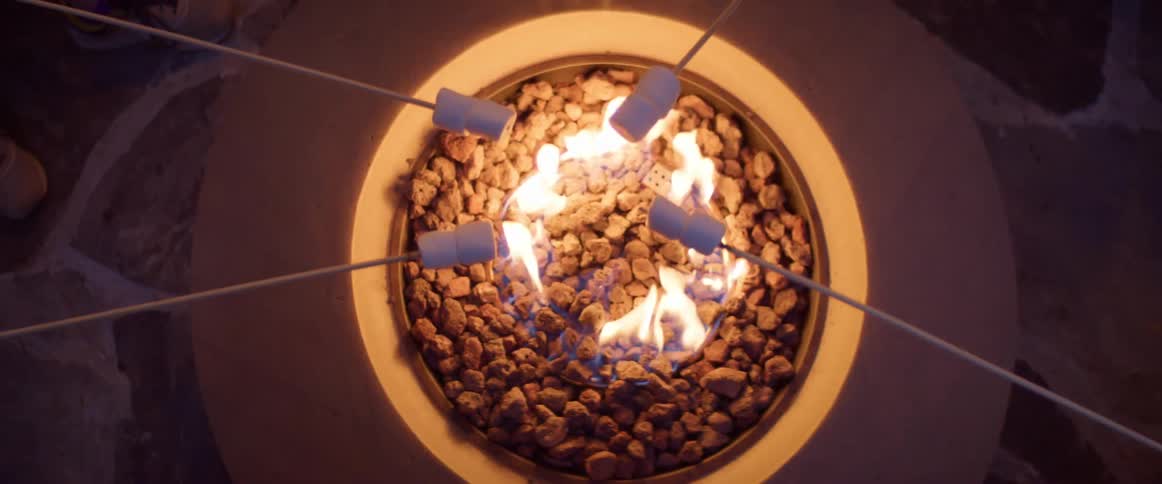 Toasting marshmallows over a fire on a patio