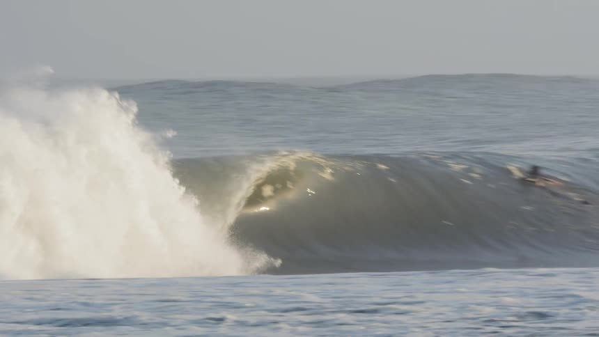 People surfing large waves in the ocean