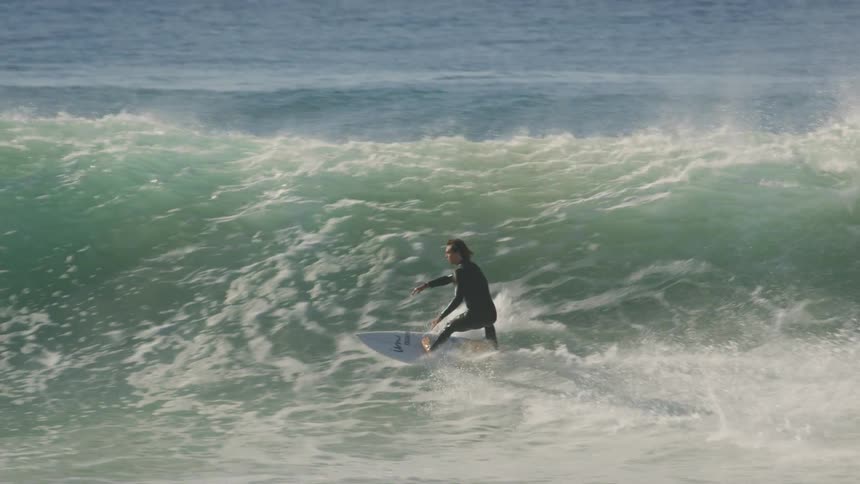 A man surfs in large waves