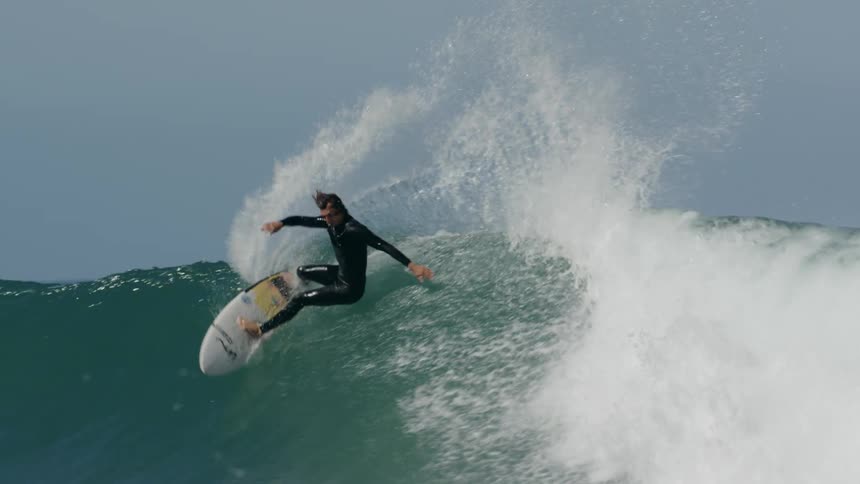 A surfer rides a tall wave in the ocean