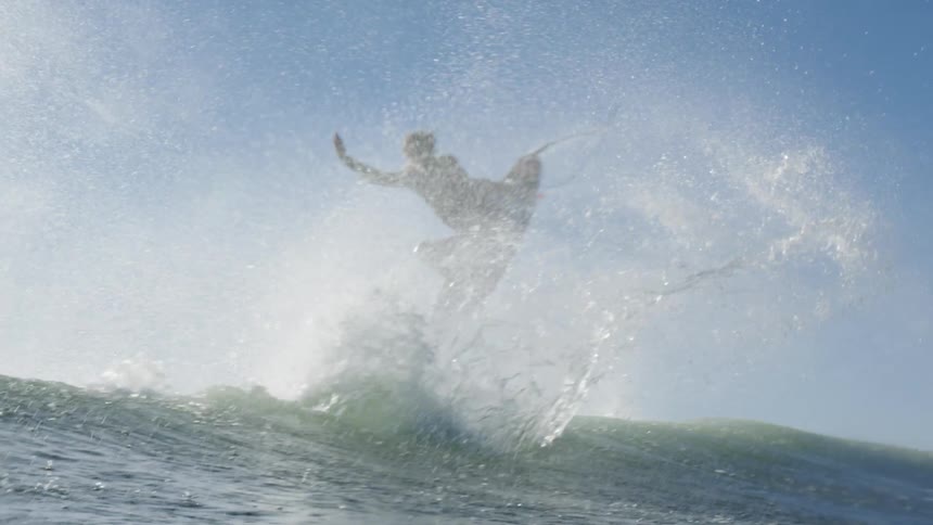 The man jumps with his surfboard out of the water