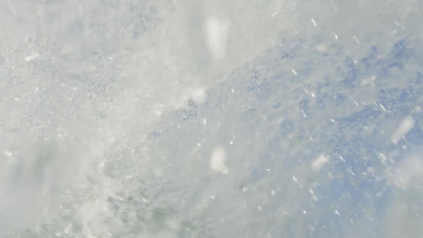 A surfer rides a wave near the shore