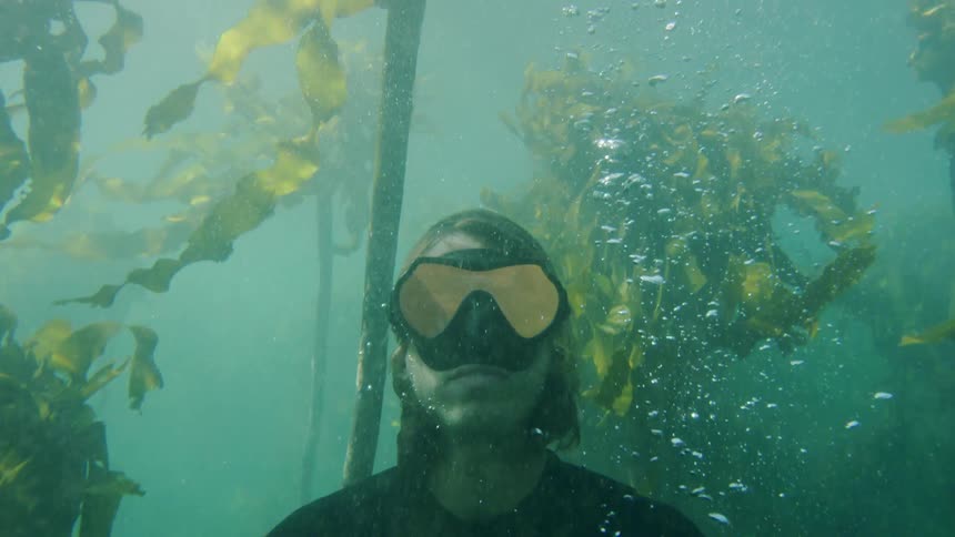 A man is underwater wearing goggles