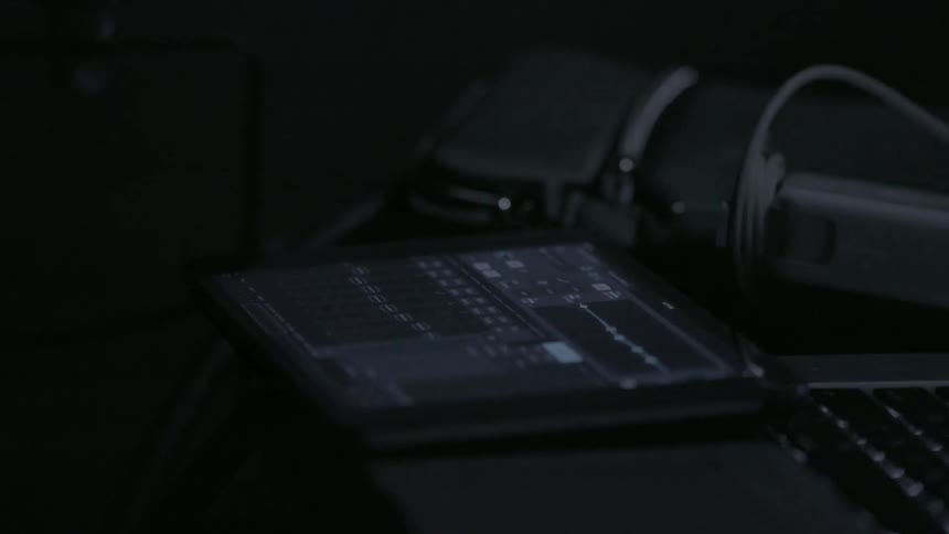 Lights flicker in a dark room filled with equipment