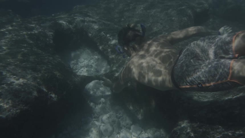 A teenager swims underwater
