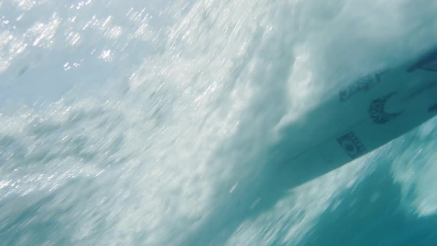 Male surfer rides on a wave on a surfboard