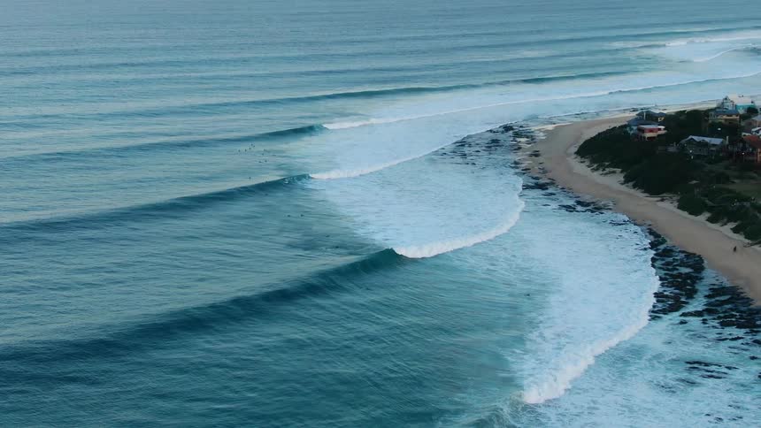 A coastal town with the ocean waves and a sandy beach