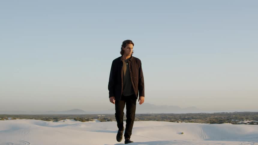 A man walks across a snow covered field