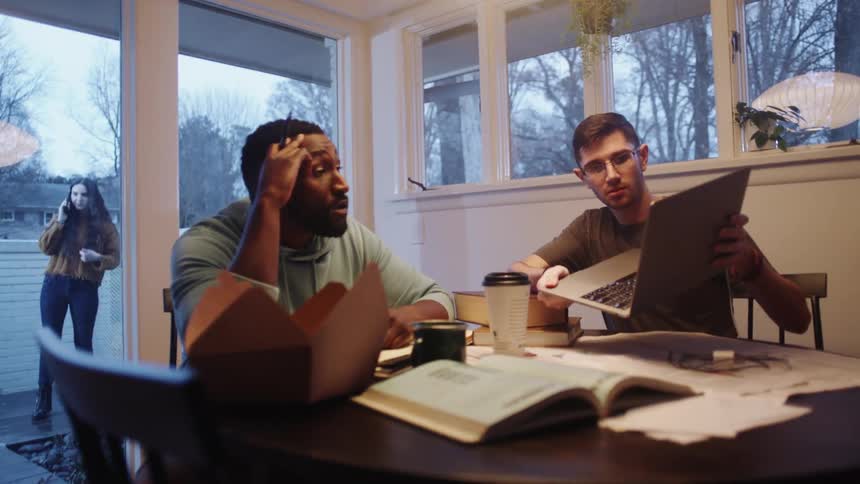 Group of friends studying on the dining room of a house