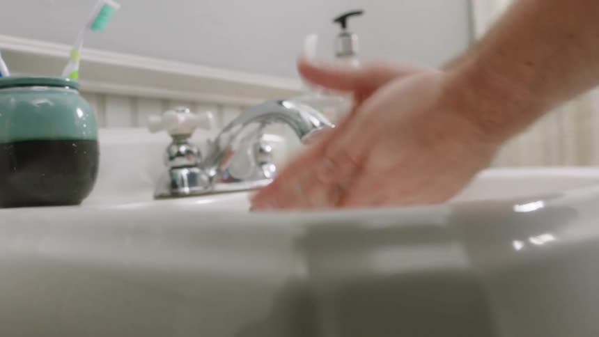 Man washes his hands with soap in the bathroom