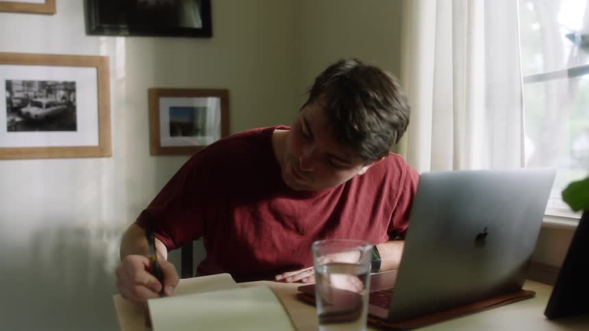 Man sitting at the desk writes down