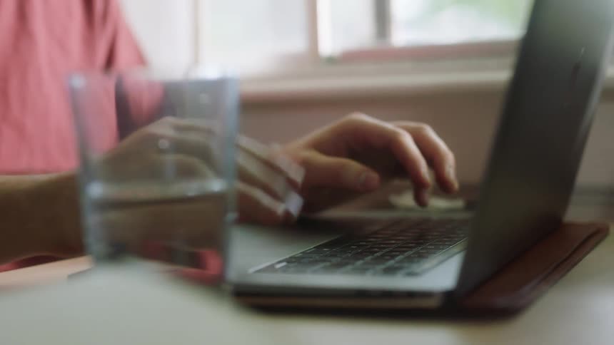 A person is typing on a laptop indoors