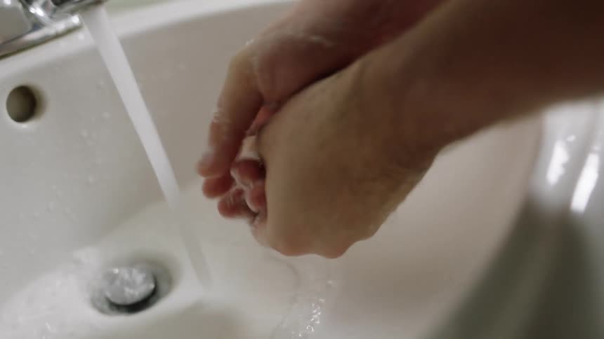 Man washes his hands in the bathroom