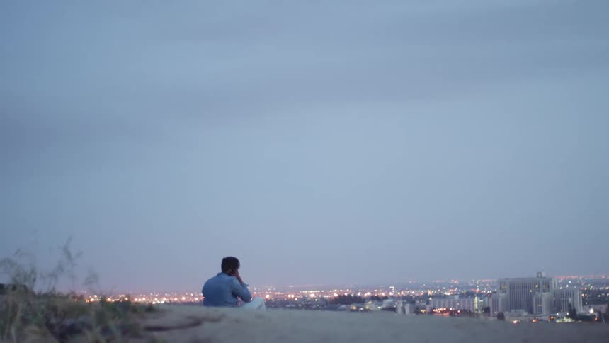 A person sits and looks at the city skyline