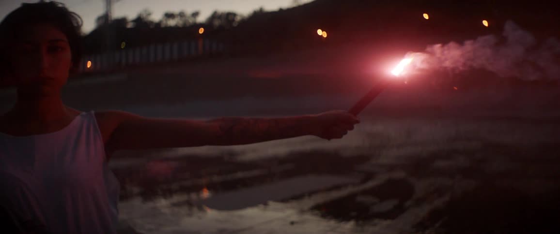 A boy is holding a candle outdoors