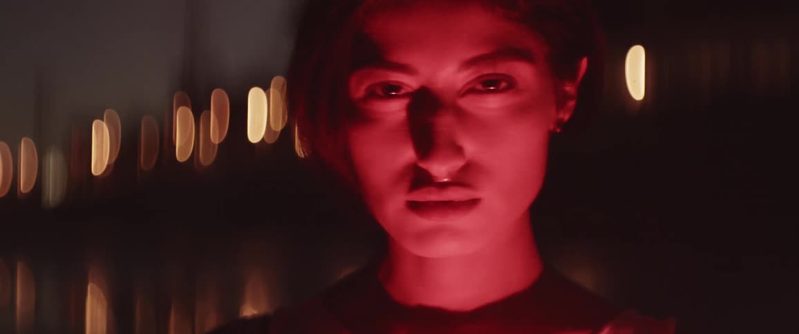 Close up of a woman face on the red light of an emergency flare at night