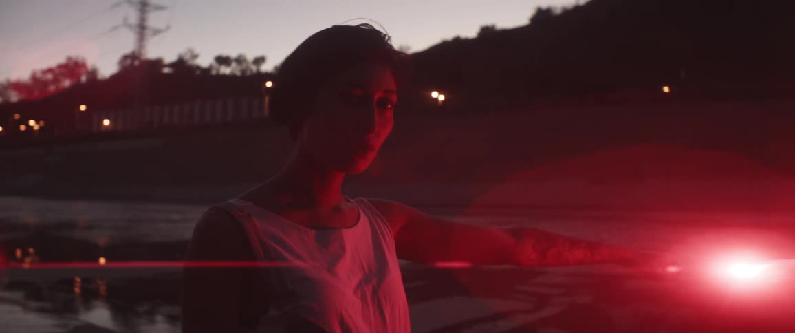 Woman holding a red emergency flare screams at the camera