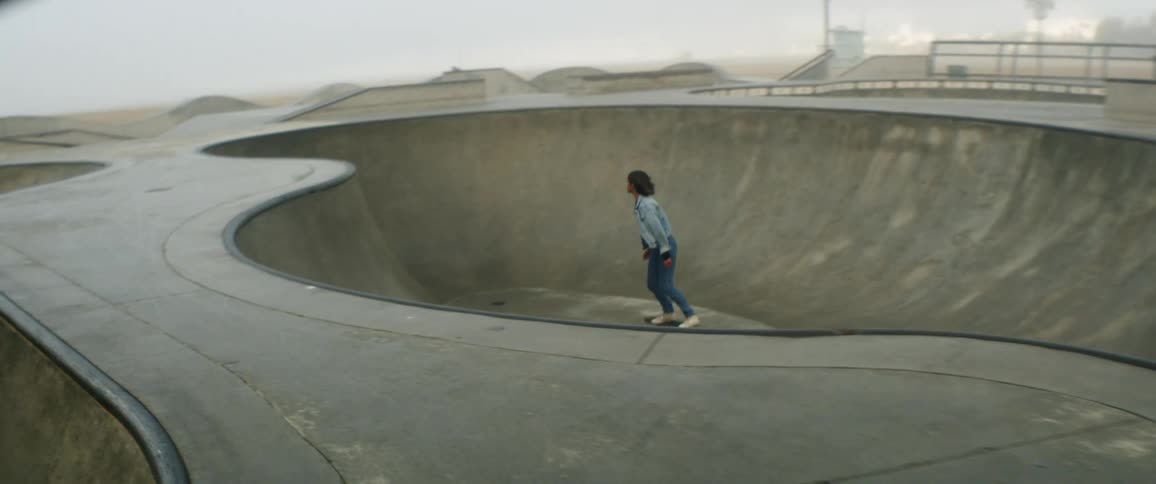 A teenager skateboards at a skate park