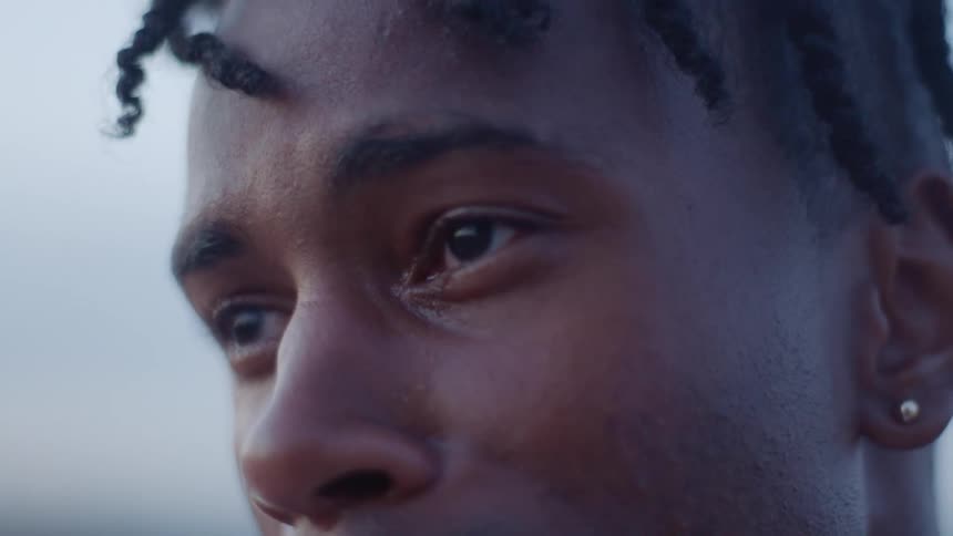 A black man closes his eyes and bows his head