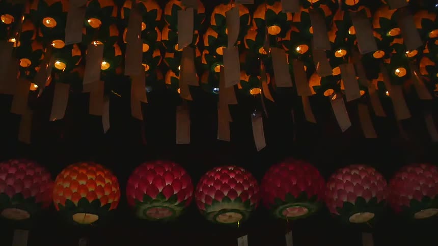 Burning lanterns hang over a shrine