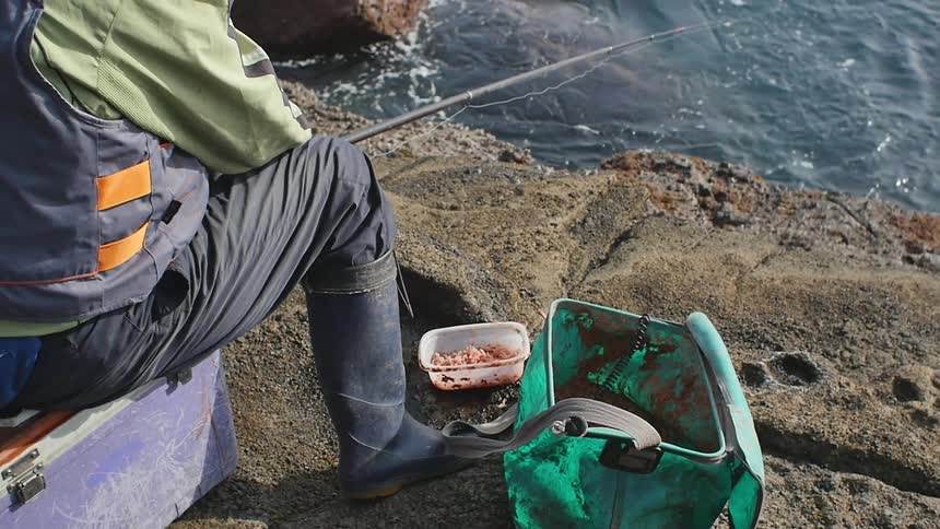 Man fishing off of a rocky cliff