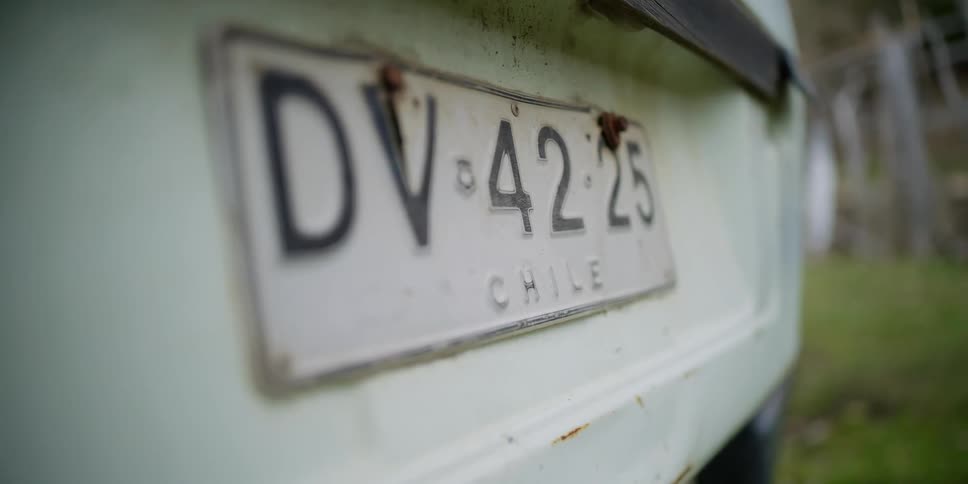 A Chilean license plate on a vehicle in the yard
