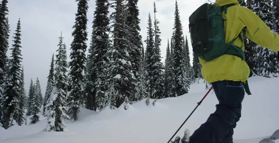 A person climbs a snow covered mountain in ski gear