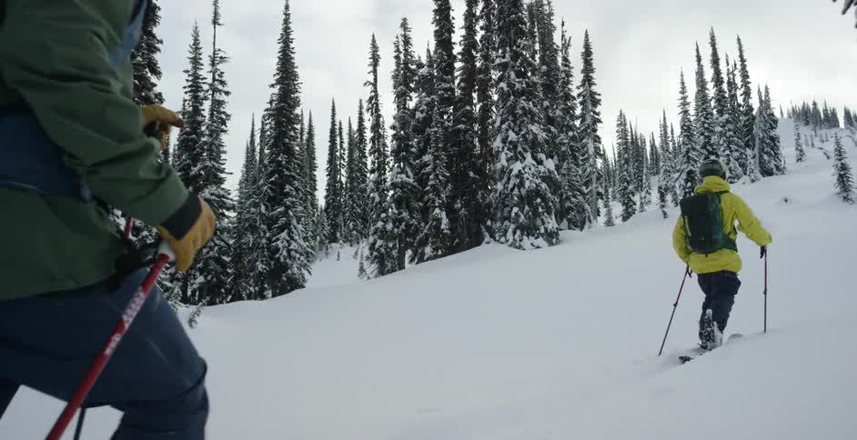 Two people climb the slope with skis