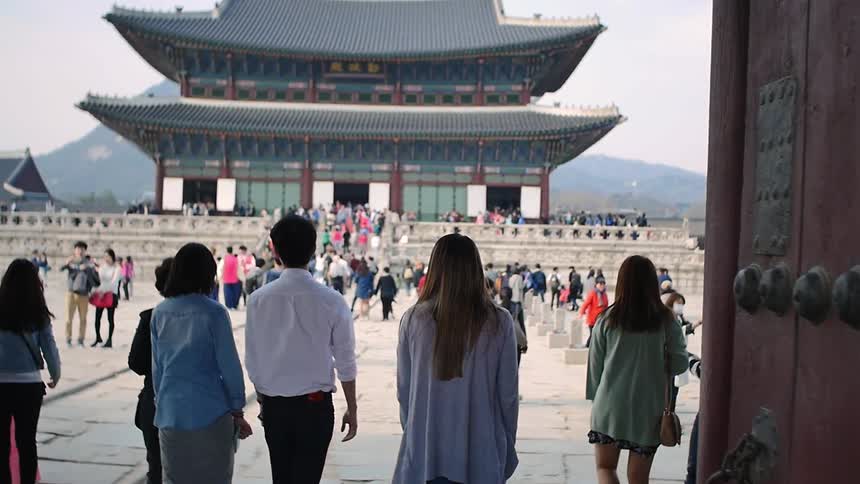 A crowd of people stand in front of a building