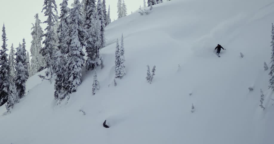 A person skis down a snow covered hill