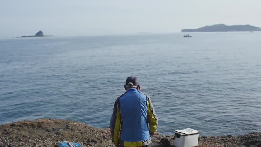 A man walks towards a lake