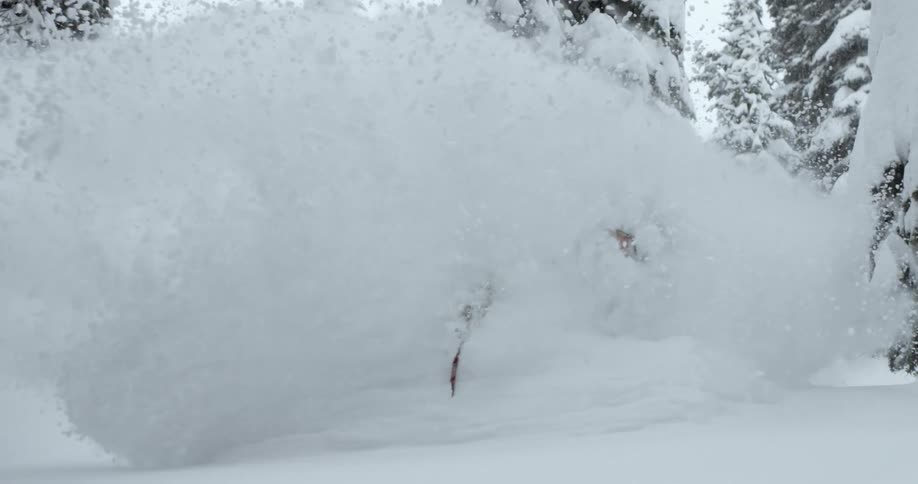 A skier sprays a huge plume of powder