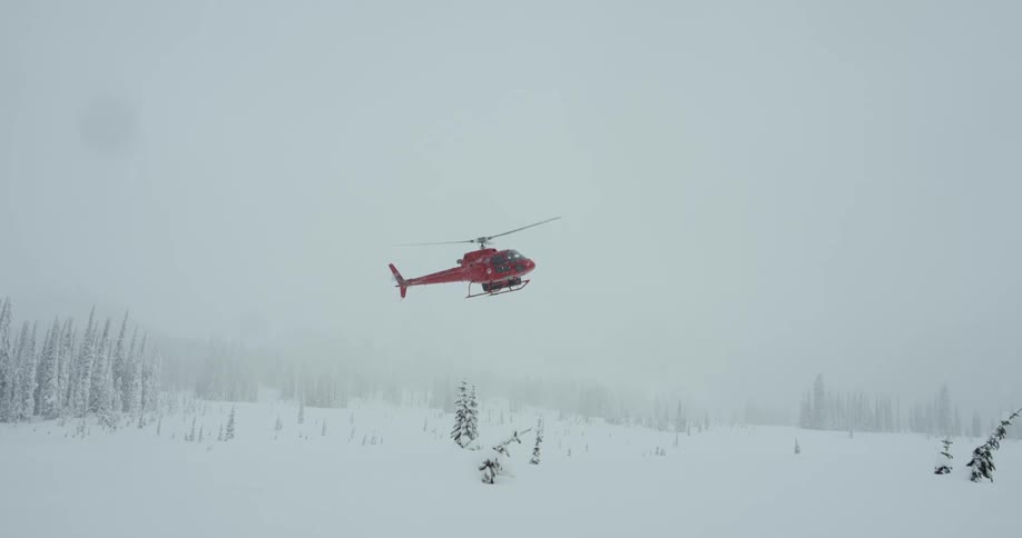 A helicopter comes in for a landing during a snowstorm outdoors