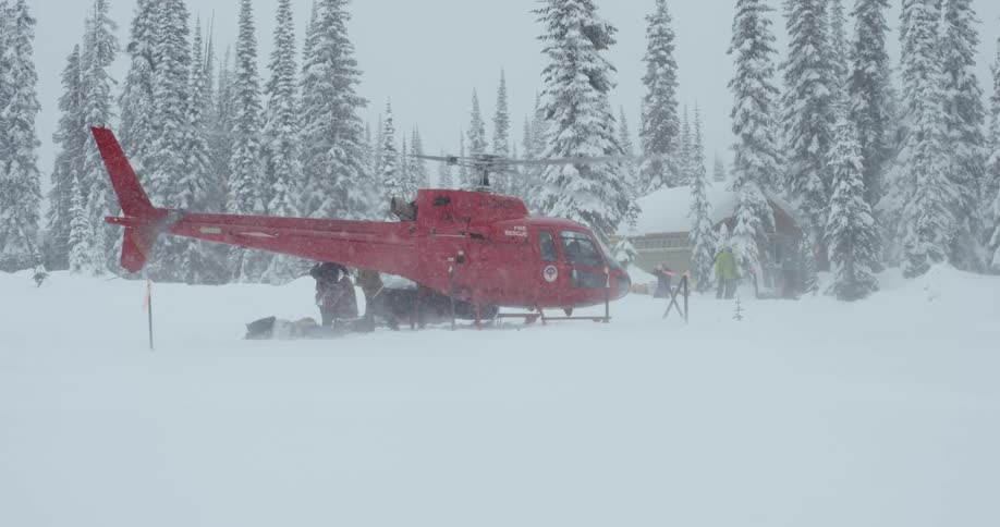 A helicopter is by a house outdoors in winter