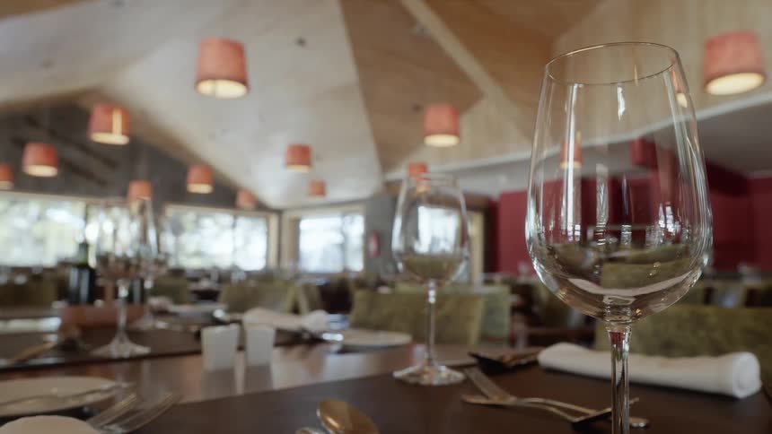 Tables are set with glasses and silverware in a restaurant