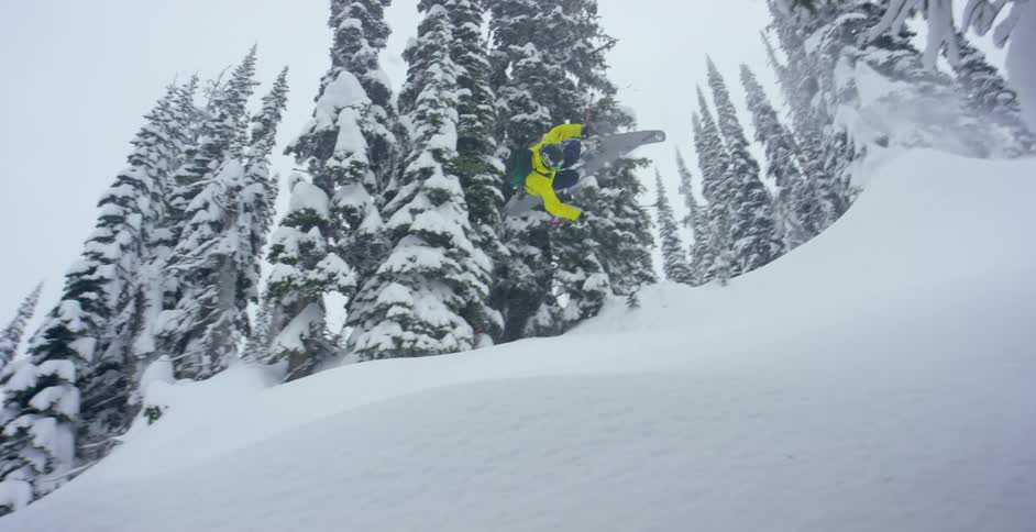 A skier jumps off a snow hill and does a flip before crashing in the fresh powder of a slope
